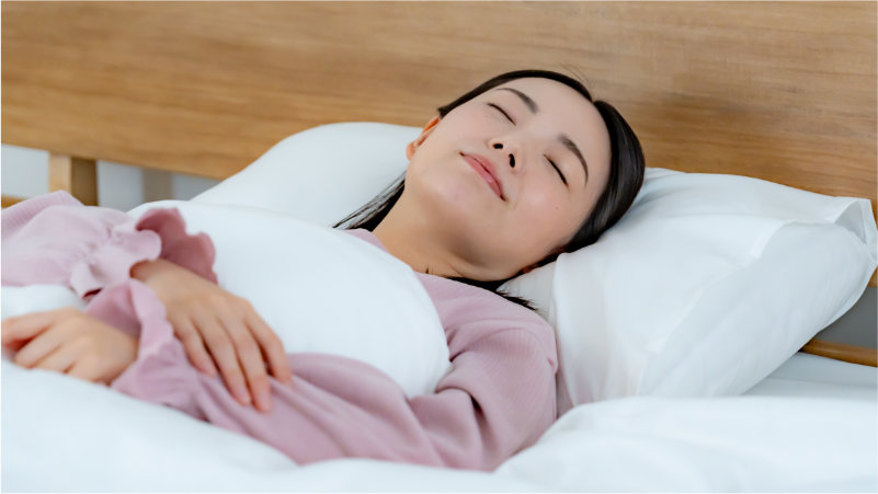 ベッドで快適に睡眠中の女性のイメージ写真